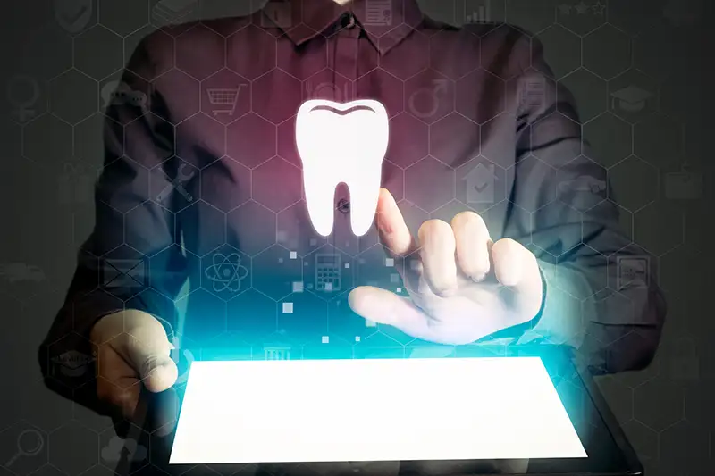 Glowing tooth floating above tablet device