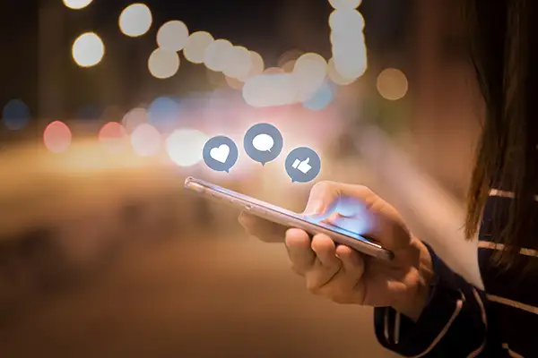 Woman hands using mobile smartphone in the street with icon social media and social network