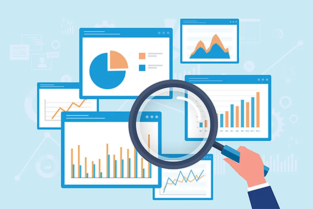 Hand holding magnifying glass above charts and graphs